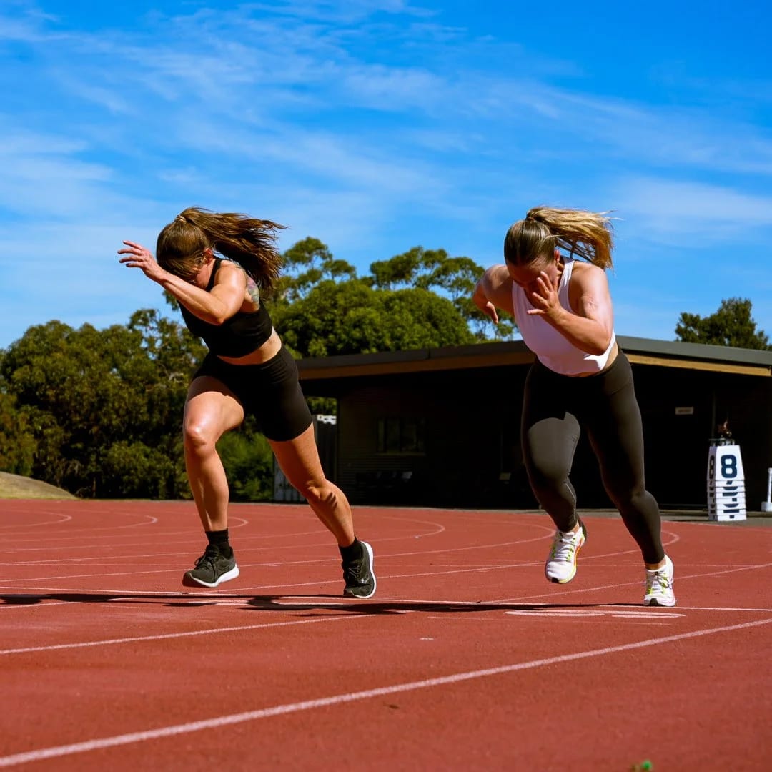 Two athletes driving out of the blocks on the track